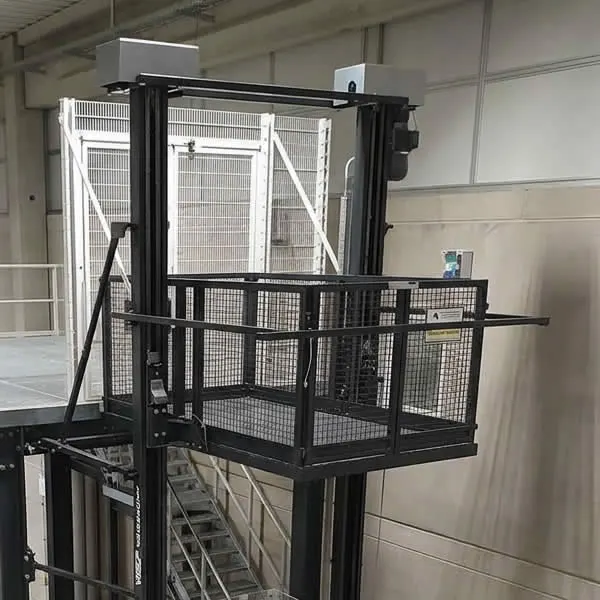 Plataforma de carga industrial instalada entre dos niveles de una planta, con cabina abierta, cerramiento metálico y accesos protegidos en Bogotá, Colombia